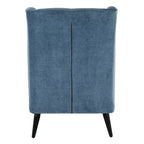 Rear view of the blue wing armchair with a central vertical seam, piping along the top edge and two visible black legs.