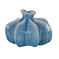 Blue vase on a white background, showing broad rounded lobes, deep vertical recesses and a short neck with a wavy flared rim.