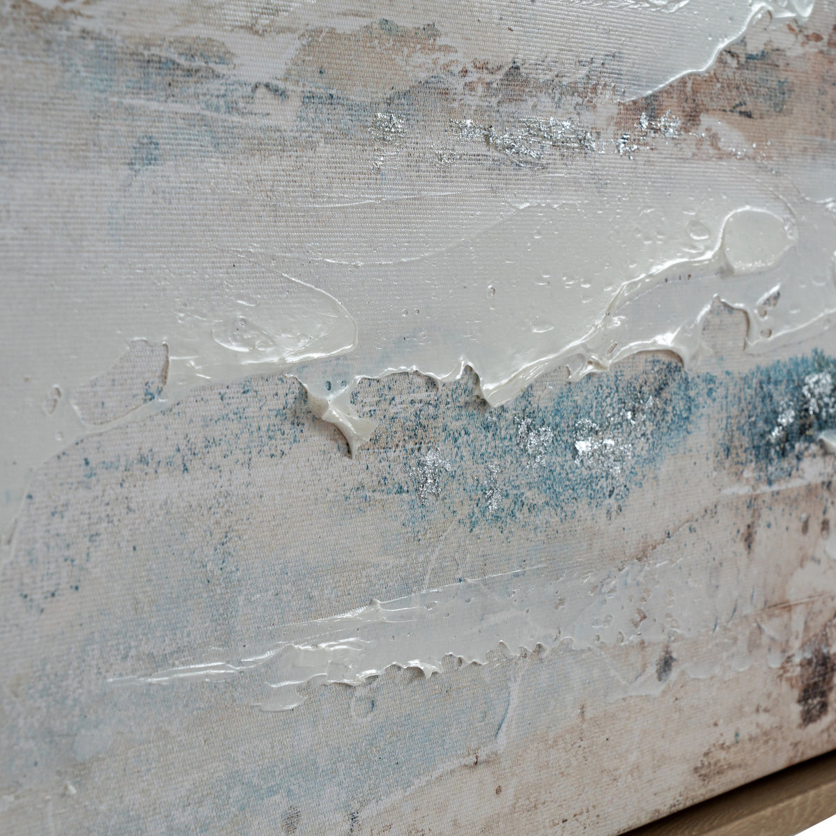Angled detail of thick white paint ridges over the canvas weave, with teal marks, warm brown patches and small silver-coloured reflective accents.