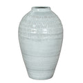 Pale blue-white vase shown in full against white, with rounded shoulders, an incised upper band and a tapered lower body.
