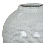 Close-up of the vase shoulder and upper body, with fine vertical incised lines visible beneath the pale speckled glaze.
