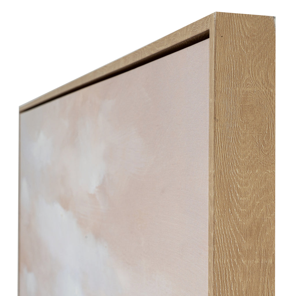 Angled detail of the upper right frame corner, showing its warm grain-like finish beside the blush canvas surface.
