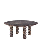 Angled view of a round burgundy marble coffee table with cream veining and four bobbin-shaped legs on a white background.