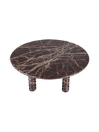 Elevated view of the circular marble tabletop, showing branching cream and caramel veins across the dark burgundy stone.