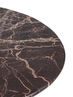 Close-up of the marble tabletop with pale irregular veining and a softly rounded outer edge.