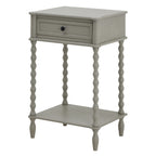 Pale grey side table shown at an angle, with a framed drawer, dark round knob, four bobbin legs and a rectangular lower shelf.