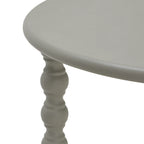 Close-up of the rounded pale grey tabletop edge and a bulbous bobbin support, showing subtle surface variation.