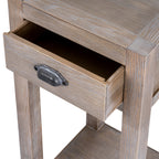 Close view of the open drawer and dark curved cup pull beneath the pale, grain-streaked tabletop.