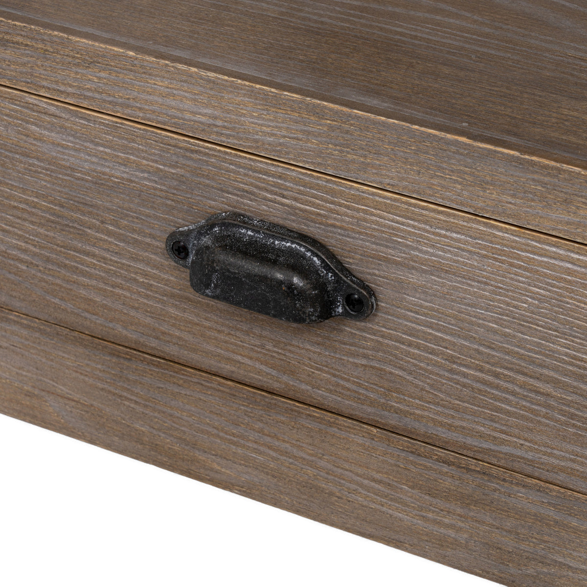 Close-up of the dark mottled cup pull against the pale grain pattern of the drawer front.