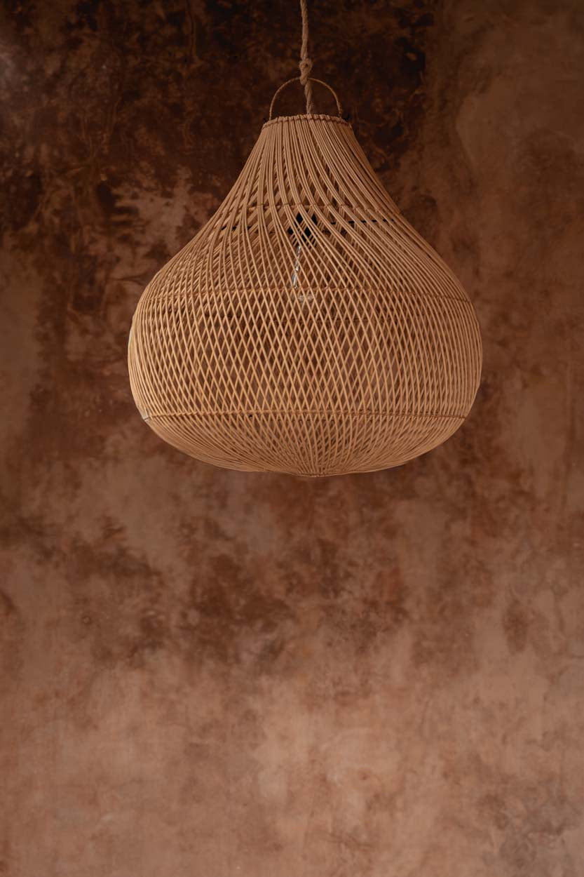 Bottle Rattan Pendant Light – Natural, Medium — styled against a warm wall