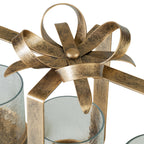 Detail of the looping metal bow and curved ribbon tails with an aged-gold finish above the glass holders.