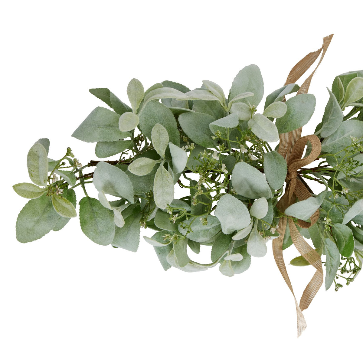 Close view of softly textured pale green oval leaves, fine branching sprays with tiny white details and the looped tan ribbon bow.