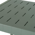 Close-up of the green-grey tabletop with broad parallel slats, staggered narrow slots and a fine linear texture.
