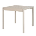 Pale putty dining table viewed at an angle, showing its broad slatted top, thick rectangular frame and four straight square legs.