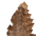 Close-up of the tree ornament's pointed top and stepped upper branches, showing dark grain lines across the brown surface.