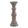 Brown candle holder with a shallow round top dish, slender contoured stem and broad stepped base against a white background.