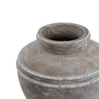 View into the planter's open neck, showing its rounded rim, dark interior and pale markings across the sloping shoulder.