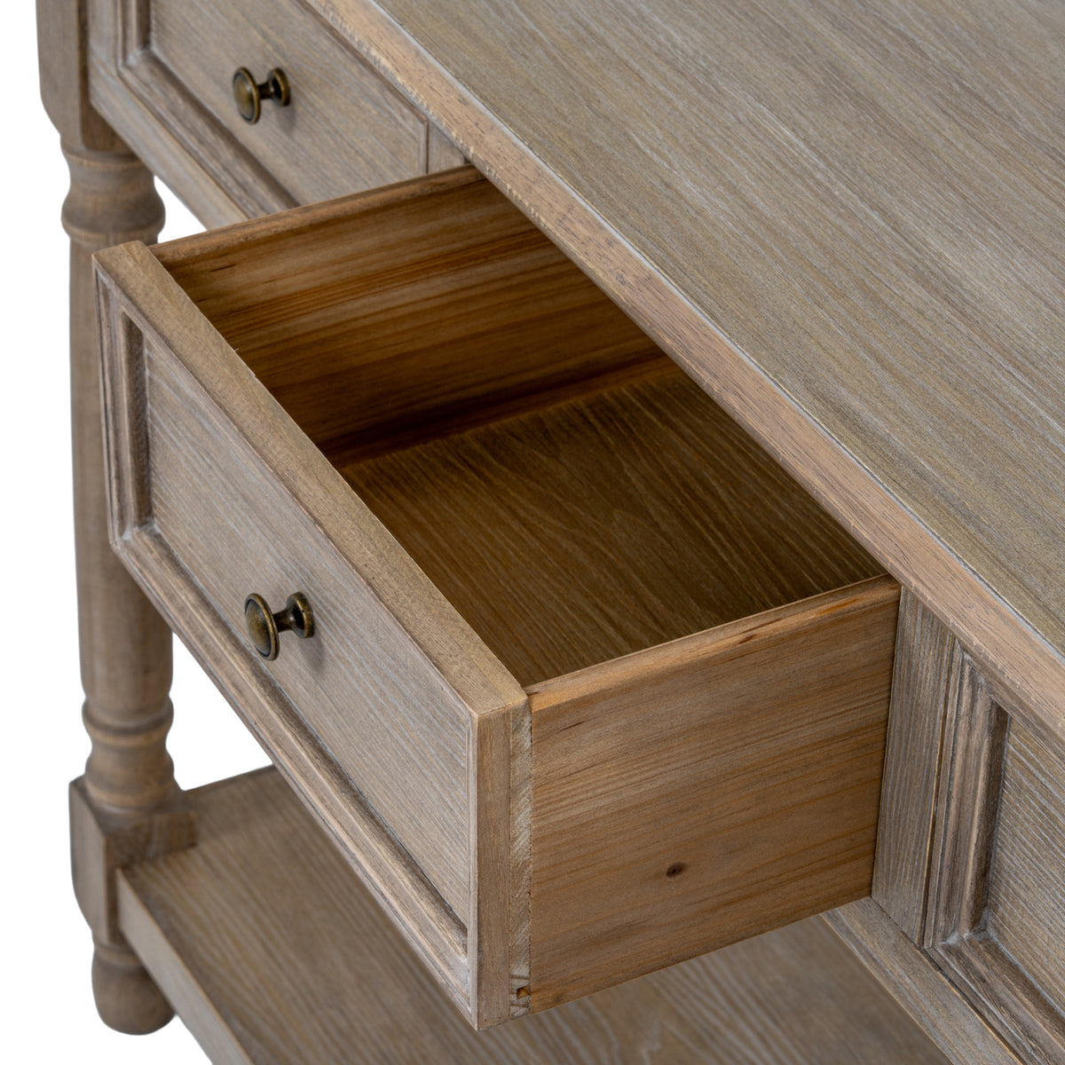 Angled close-up of an open console drawer, showing its empty interior, framed front and dark round pull beneath the grain-patterned top.