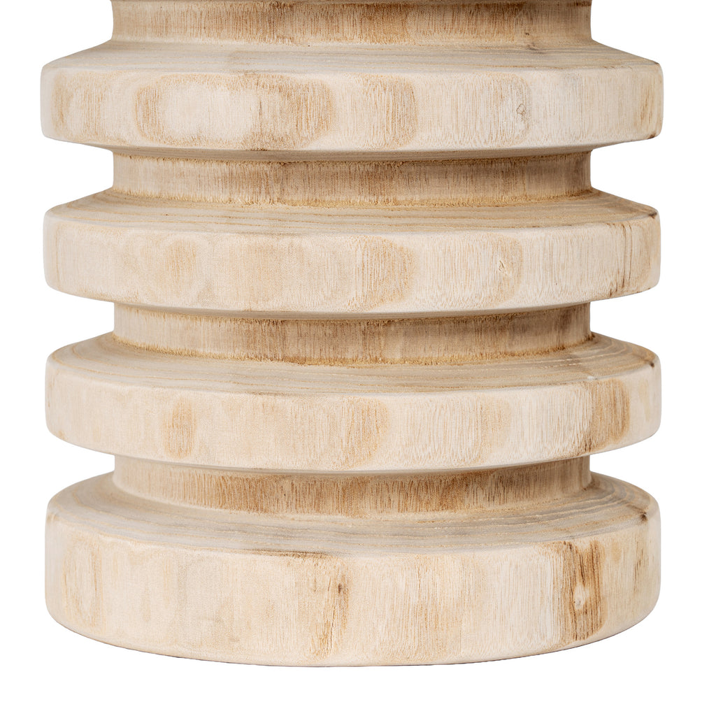 Close-up of the vase's lower ribs, showing fine brown grain on pale bands and deeper shaded recesses.
