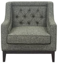 Front view of a green woven armchair with a diamond-buttoned back, deep seat cushion and dark wooden base.