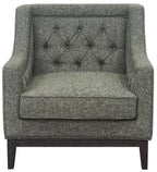 Front view of a green woven armchair with a diamond-buttoned back, deep seat cushion and dark wooden base.