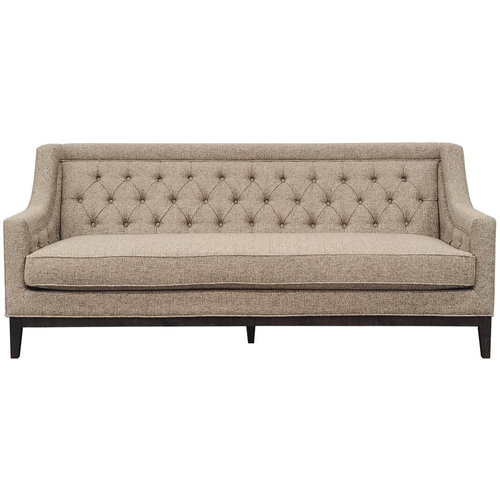 Front view of a taupe sofa with a diamond-buttoned back, long piped seat cushion and dark wooden base.
