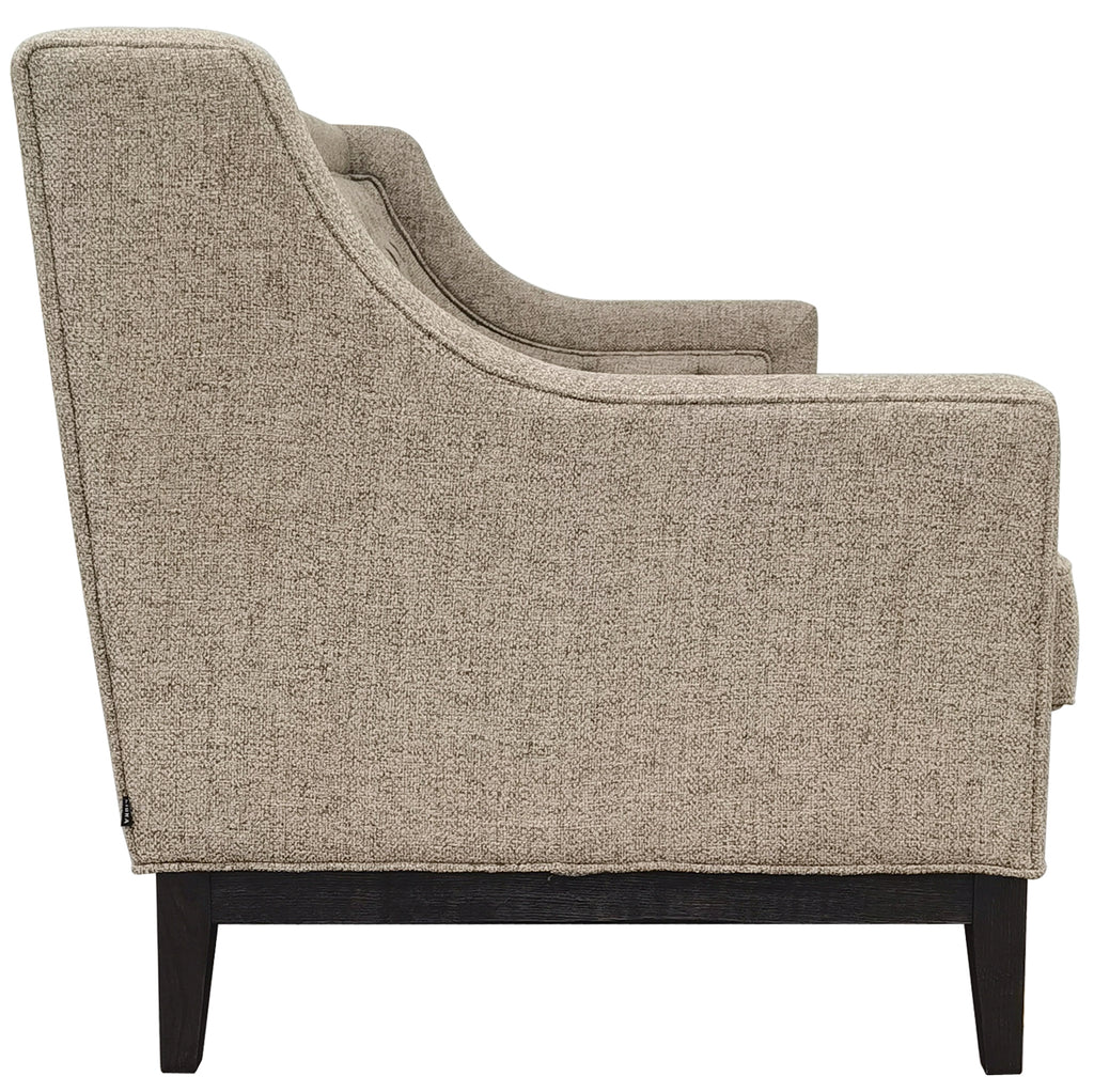 Side view of the taupe sofa showing the curved arm profile, textured upholstery and dark wooden support.