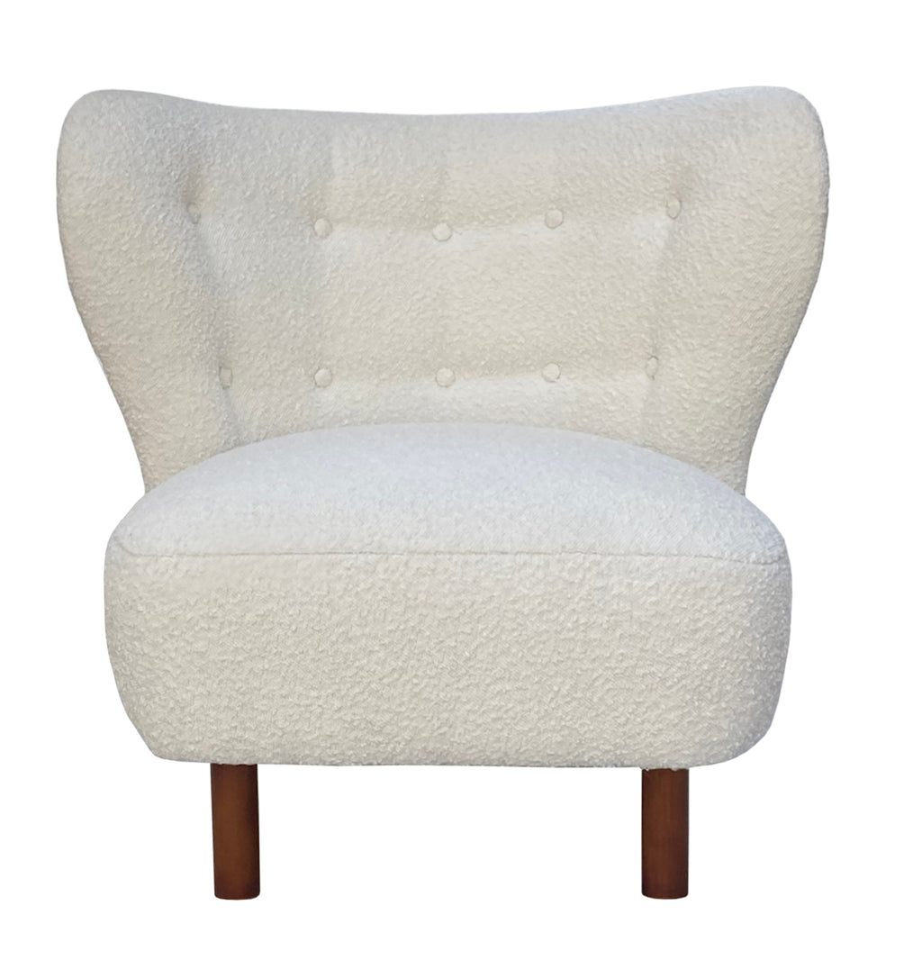 Front view of a cream bouclé chair with a wide buttoned wingback, rounded armless seat and brown wooden legs.