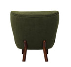 Straight rear view of the chair showing its broad upholstered back, curved piping and two splayed brown wooden rear legs.