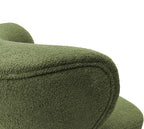 Close-up of the green bouclé chair back showing the looped fabric texture and piping around its rounded edge.