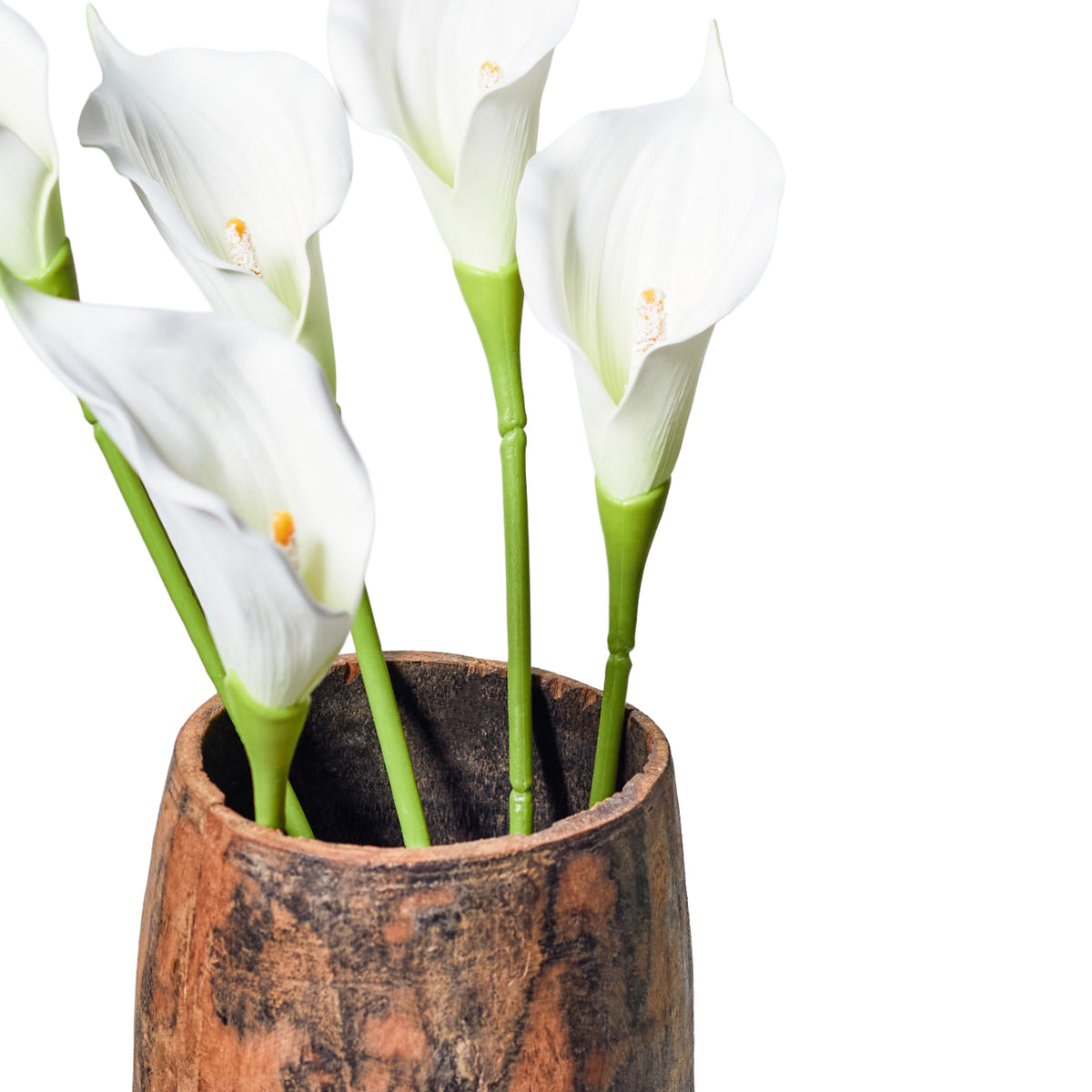 Close-up of several cream faux calla lilies with orange-tipped centres and green stems in a mottled brown vase against a white background.