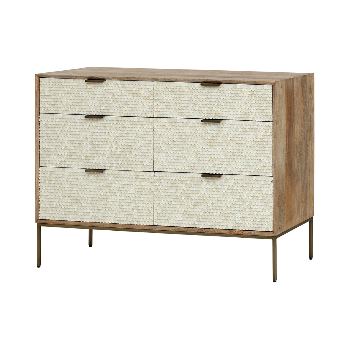 Three-quarter view of the Cartouche chest with six cream scalloped drawer fronts, a light wood frame and slender brass-toned legs.