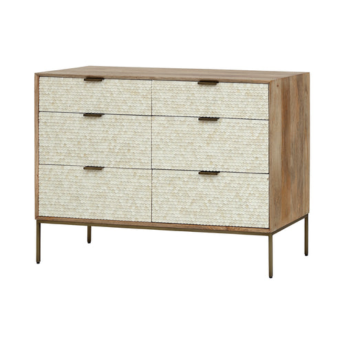 Three-quarter view of the Cartouche chest with six cream scalloped drawer fronts, a light wood frame and slender brass-toned legs.