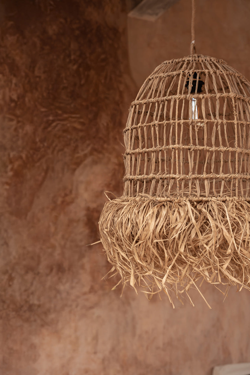 Casita Mendong Grass Pendant Light – Natural, Large – full hanging view against a terracotta wall