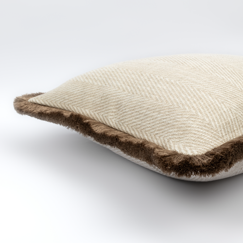Angled view of the Caspian Cushion showing its cream herringbone weave and mushroom fringe