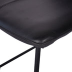 Close-up of the rounded leather seat corner and stitched border above the black tubular frame.