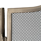 Close-up of the textured antiqued silver-tone frame beside a hinge, with the black diamond mesh visible within the panel.