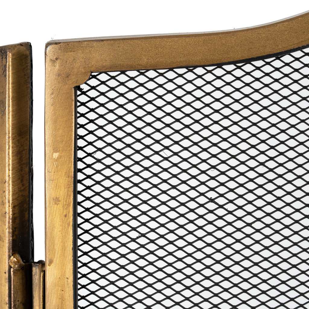 Close-up of the antiqued brass-tone frame beside a hinge, showing its varied surface colour and the black expanded diamond mesh.