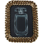 Front view of a gold chain-link photo frame with a white perfume-bottle drawing on a black insert.