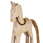 Close-up of the horse's upright ears, black dot eyes and dark chain bridle against its pale, white-accented surface.