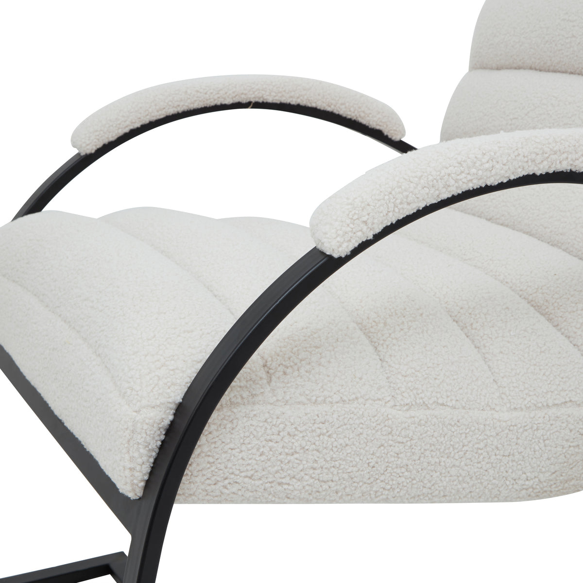 Close view of the pale looped upholstery across the channelled seat and arm caps, with black curved arm supports.