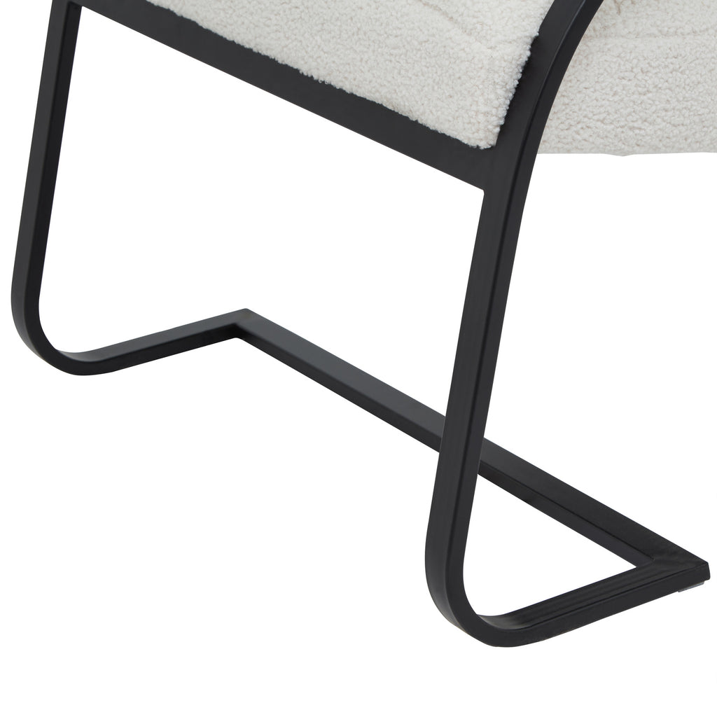 Detail of the flat-faced black runner base, showing its curved lower corners and angular floor outline beneath the pale seat.