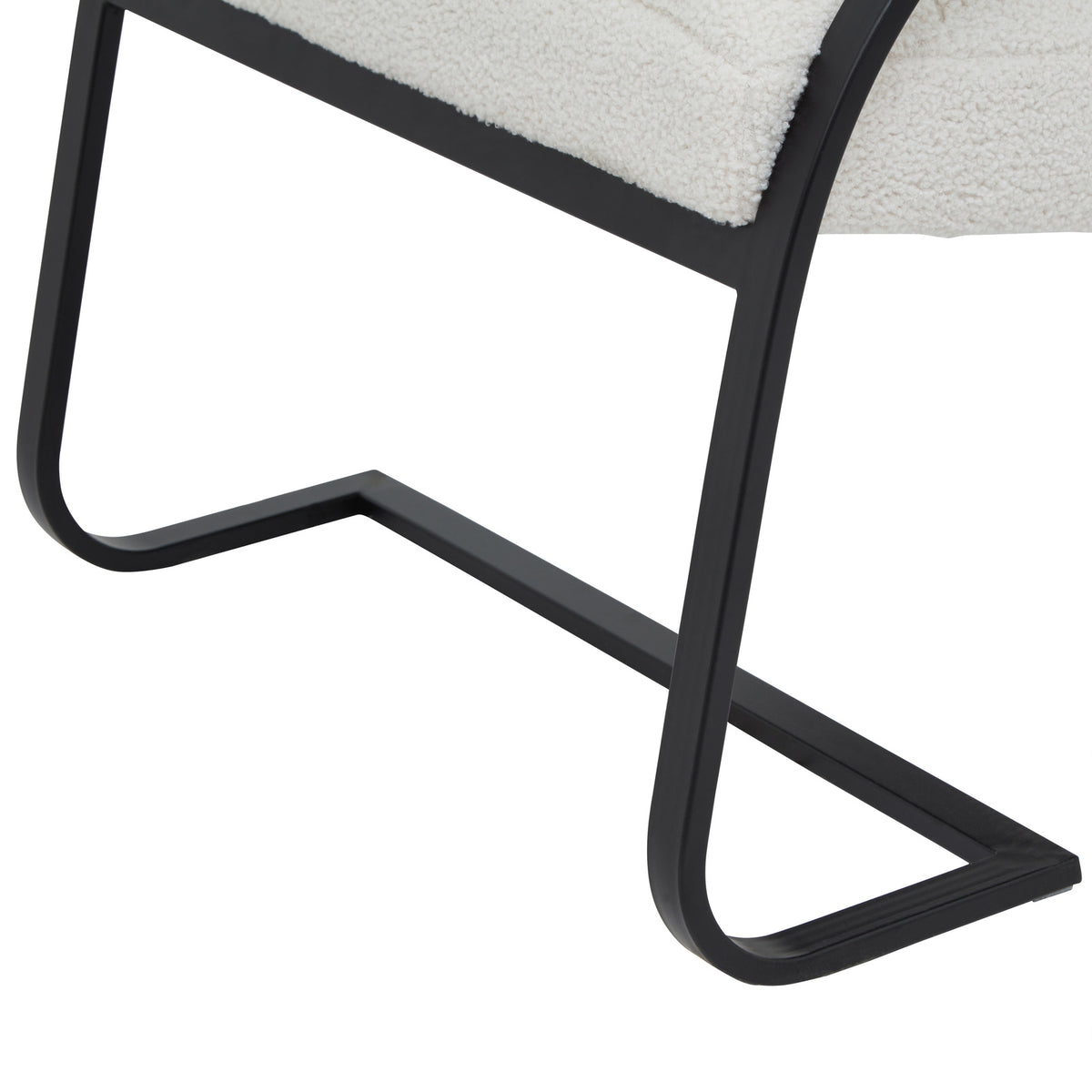 Detail of the flat-faced black runner base, showing its curved lower corners and angular floor outline beneath the pale seat.