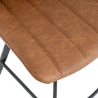 Close-up of the tan seat showing its mottled surface, stitched channels and rounded edge, with part of the black base below.
