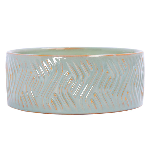 Front view of the shallow blue-green ceramic candle bowl with glossy wave-like grooves and ochre detailing.