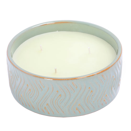 Angled view of the Chant Candle showing pale wax, three white wicks and the patterned blue-green ceramic bowl.