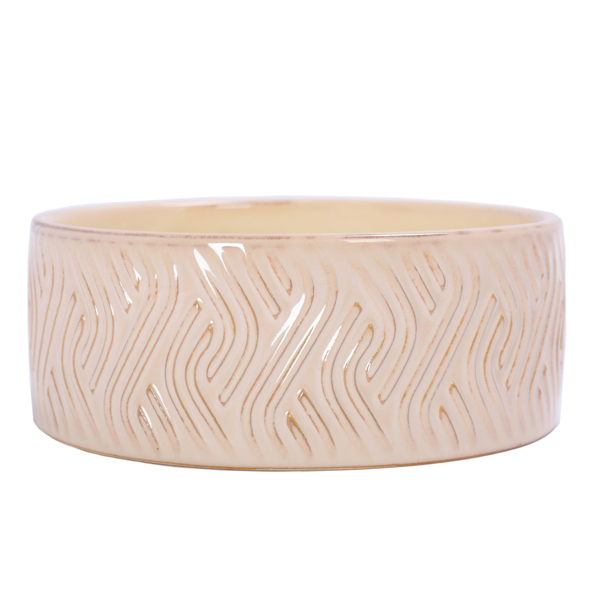 Low front view of the ivory candle bowl, showing repeating flame-like grooves and honey-brown accents beneath a glossy glaze.