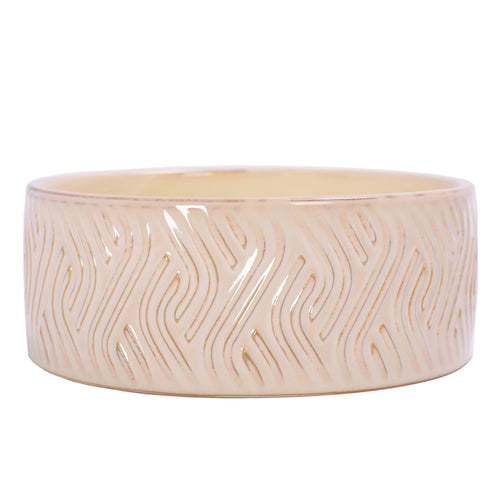 Low front view of the ivory candle bowl, showing repeating flame-like grooves and honey-brown accents beneath a glossy glaze.