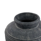 Angled close-up into the planter's dark opening, showing the rounded rim and pale markings across the neck and sloping shoulder.
