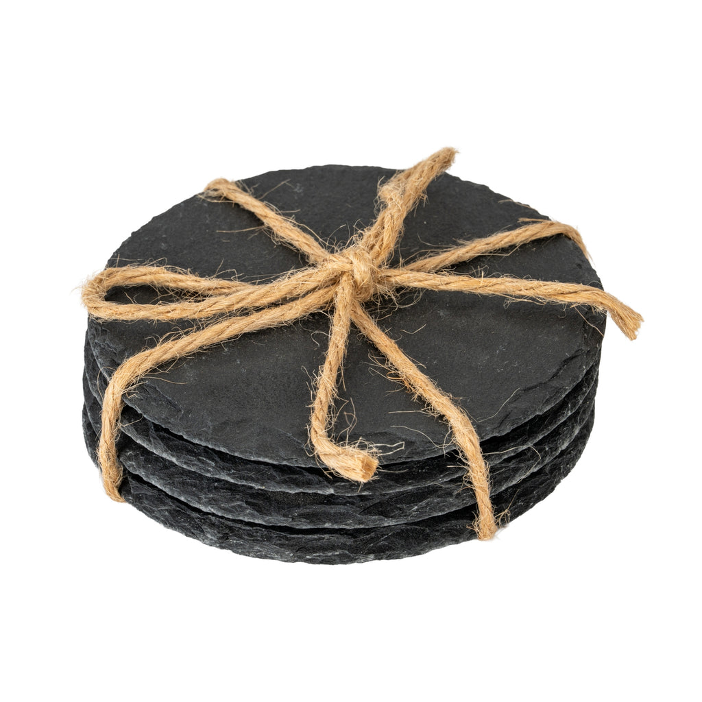 Stack of dark charcoal round coasters tied with tan twine, showing irregular outlines and rough layered edges against a white background.